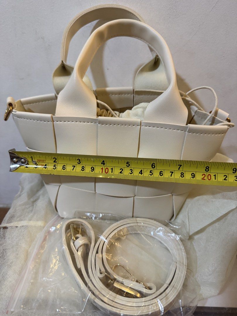 White Woven Leather Bucket Bag with Strap (Category: Shoulder Bags) located in Bulacan. Submitted by emjay_17 (Listing ID 1470408159, Image 3). Description: - Color & Material: White woven faux leather - Design: Structured checkerboard pattern - Features: Top handles and a secure drawstring inner pouch - Strap: Includes an adjustable, detachable matching white shoulder strap (still wrapped in plastic) - Condition: Brand new, never used, with a pe