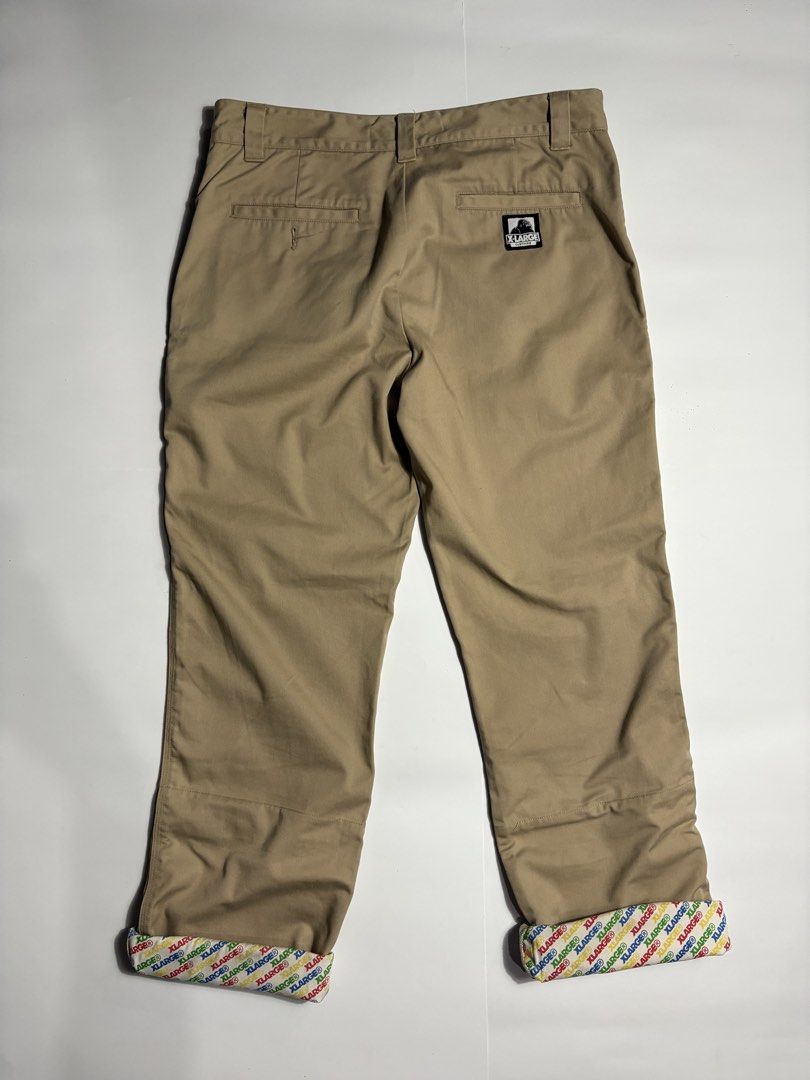 Xlarge Beige Work Pants (Category: Trousers) located in San Fernando. Submitted by lumang_gamit (Listing ID 1470396961, Image 3). Description: - Brand: XLARGE - Color: Tan - Style: Classic streetwear work pants - Details: Woven logo patch on back pocket - Special Feature: Cool colorful branded print lining inside waistband and cuffs (great for rolling up) - Condition/Fabric: Solid everyday trousers made with sturdy fabric.