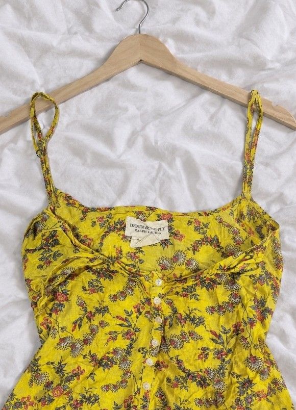 Yellow Floral Button-Down Cami Top 💓🪽 (Category: Sleeveless) located in Batangas. Submitted by itgirl.archive (Listing ID 1470372343, Image 2). Description: Brand: Denim & Supply Ralph Lauren Size: Small to Medium Color: Mustard yellow with multicolor floral prints Material: Lightweight, breathable-looking fabric Design: Spaghetti straps, sweetheart neckline, ruched bust, and white front buttons Style: Vintage, cottagecore, boho, Y2K Condition: