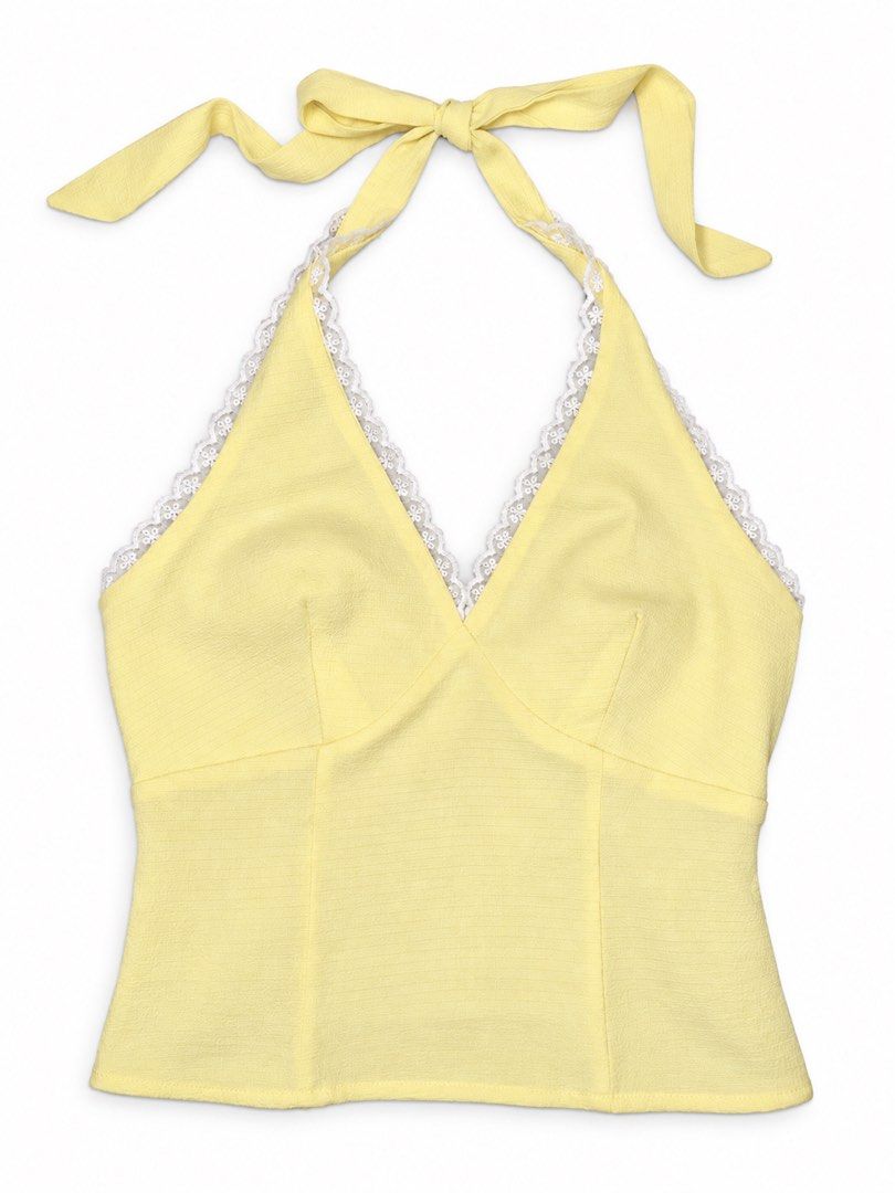 Yellow Halter Top with White Lace Trim (Category: Sleeveless) located in Cabanatuan. Submitted by wantsomethrifts (Listing ID 1470543268, Image 1). Description: - Color: Bright yellow - Design: Halter top with delicate white lace trim along the V-neck - Closure: Ties at the back of the neck with a matching fabric bow - Details: Textured fabric with structured seams down the front - Styling: Great pop of color for sunny days, easy to pair with hig