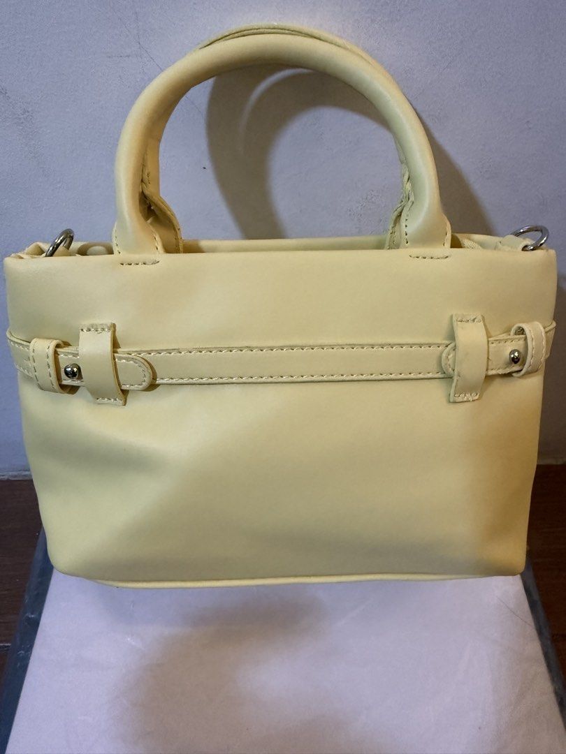 Yellow Mini Handbag With Detachable Strap (Category: Purses & Pouches) located in Bulacan. Submitted by emjay_17 (Listing ID 1470406365, Image 2). Description: - Color: Bright yellow - Material: Premium faux leather - Dimensions: Approx. 20 cm (W) x 15 cm (H) - Straps: Top carry handles + long adjustable shoulder strap - Closure: Secure zip-shut main compartment - Details: Horizontal front strap with silver-tone hardware studs - Condition: Clean 