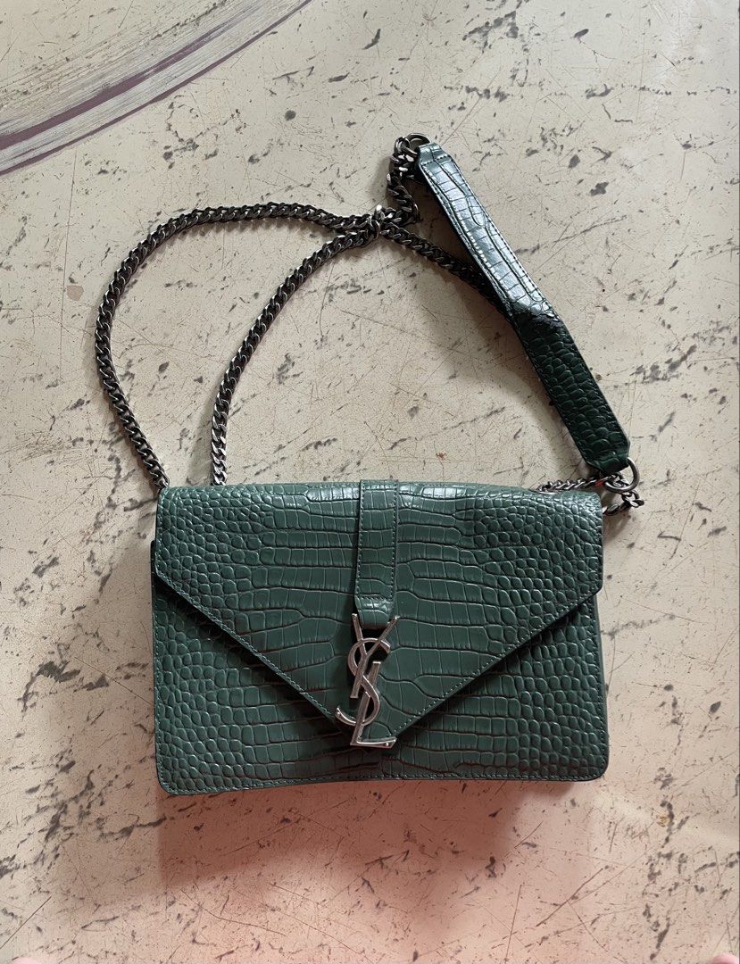 YSL - SAINT LAURENT CASSANDRA (Category: Luxury Bags & Wallets) located in Cagayan de Oro. Submitted by jericc1 (Listing ID 1470490770, Image 1). Description: - Brand: Yves Saint Laurent (YSL) - Model: Cassandra Handbag - Color: Dark Green with Croc-Embossed Finish - Hardware: Silver-tone with signature YSL interlocking logo - Strap: Chain strap with leather shoulder guard - Condition: 7/10 (shows minor wear/flaw on the strap as seen in photos) -