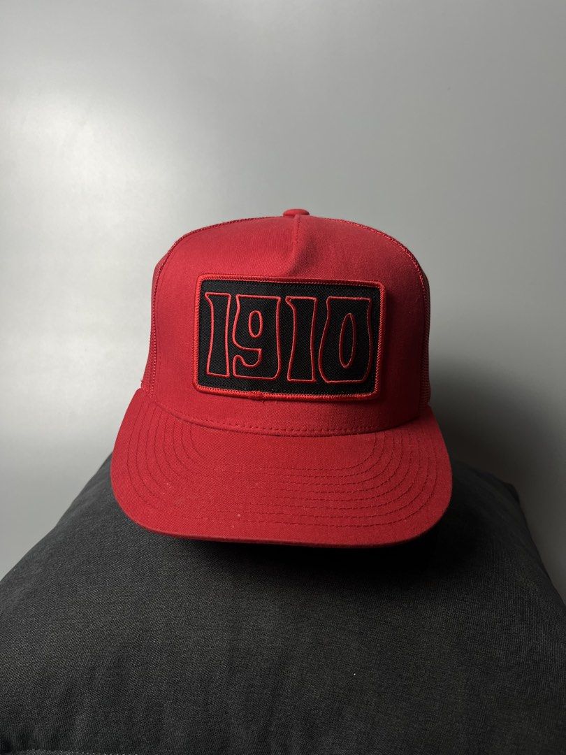 Yupoong The Classics 1910 Trucker Hat Red Snapback (Category: Caps & Hats) located in Dagupan City. Submitted by loves2thrifth (Listing ID 1470369452, Image 1). Description: - Brand: Yupoong The Classics - Style: Trucker hat with structured front panels and breathable mesh back - Design: Embroidered black and red '1910' patch on the front crown - Color: Vibrant red with matching red adjustable plastic snapback closure - Condition: Clean all aroun
