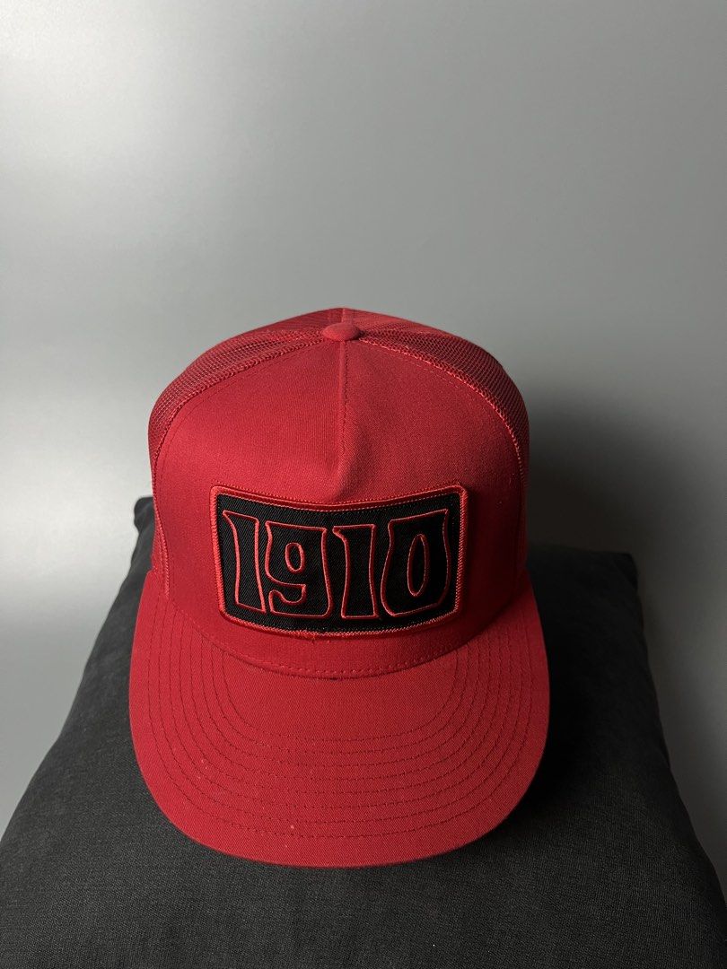 Yupoong The Classics 1910 Trucker Hat Red Snapback (Category: Caps & Hats) located in Dagupan City. Submitted by loves2thrifth (Listing ID 1470369452, Image 2). Description: - Brand: Yupoong The Classics - Style: Trucker hat with structured front panels and breathable mesh back - Design: Embroidered black and red '1910' patch on the front crown - Color: Vibrant red with matching red adjustable plastic snapback closure - Condition: Clean all aroun