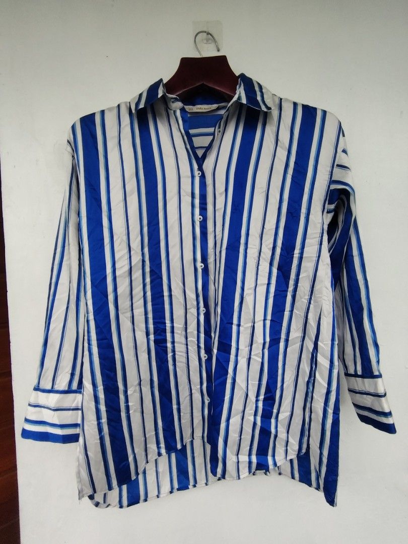 ​Zara Basic Blue & White Striped Long Sleeve Satin-Finish Blouse | Size XS (Category: Others Tops) located in Pandi. Submitted by thriftcircuit (Listing ID 1470452219, Image 1). Description: Zara Basic Vertical Striped Button-Down Blouse ​💙 Elegant and versatile Zara Basic long-sleeve button-up blouse featuring vibrant royal blue and white vertical stripes. Silky, satin-like finish with a high-low asymmetrical hem that looks great tucked in or s
