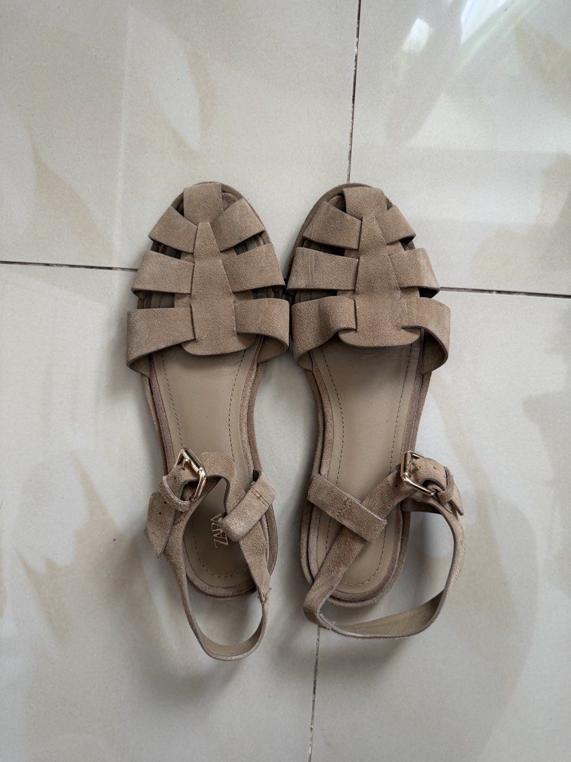 ZARA Beige Suede Flat Sandals Size 37 (Category: Flats & Sandals) located in Makati City. Submitted by andzr. (Listing ID 1470425584, Image 1). Description: ZARA beige suede sandals in size 37. Flat style with woven strap design across the top. Adjustable ankle strap with gold-tone buckle. Soles show light signs of wear from walking. Soft material, comfortable fit for daily outfit pairings..