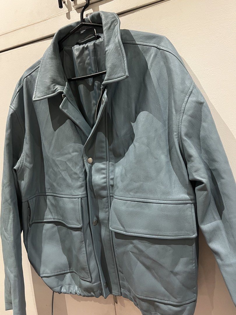 Zara Blue Grey Leather Jacket with Front Pockets (Category: Coats, Jackets and Outerwear) located in Quezon City. Submitted by Zandee (Listing ID 1470486877, Image 2). Description: - Color: Blue-grey - Material: Soft textured leather with a lined interior - Closure: Full zip and snap button closure - Pockets: Two large front flap pockets on the chest - Fit: Adjustable drawstring hem at the waist - Style: Collared neck.