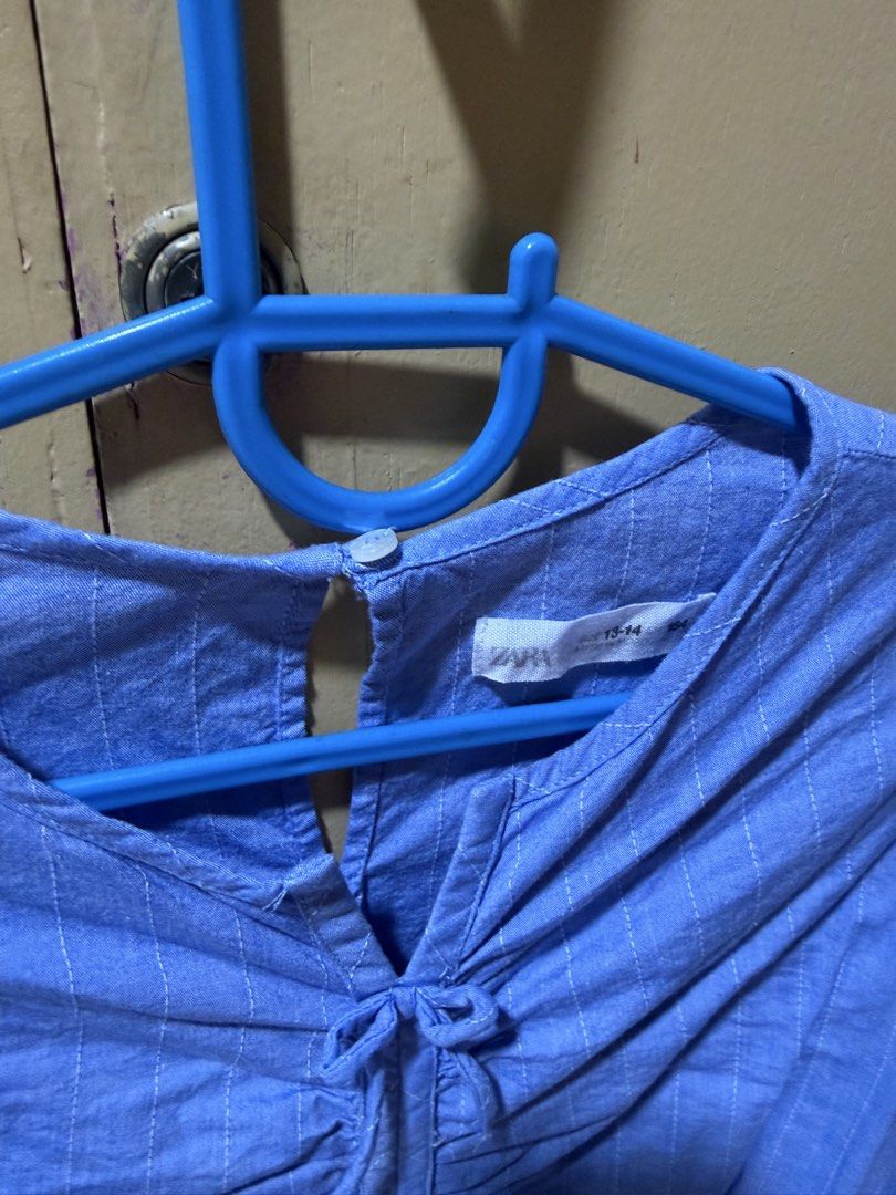 Zara Blue Ruched Crop Blouse (Category: Blouses) located in Quezon City. Submitted by delideclutters (Listing ID 1470538851, Image 3). Description: - Brand: Zara - Size: 13-14 years (164 cm) - Color: Light blue with subtle vertical pinstripes - Design: Crop blouse with long sleeves and back neckline button closure - Details: Adjustable front ruching with drawstrings, plus elastic hem and cuffs for a comfortable fit - Condition: Great pre-loved co