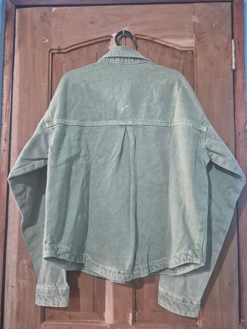 Zara Green Denim Jacket (Category: Coats, Jackets and Outerwear) located in Makati City. Submitted by neri_11 (Listing ID 1470419940, Image 3). Description: - Brand: Zara - Color: Trendy sage green - Condition: Brand new with original hang tag attached (includes a minor spot near the back yoke seam) - Details: Button-up front, metallic hardware, two chest pockets, long sleeves with button cuffs - Perfect layering piece for any casual outfit .