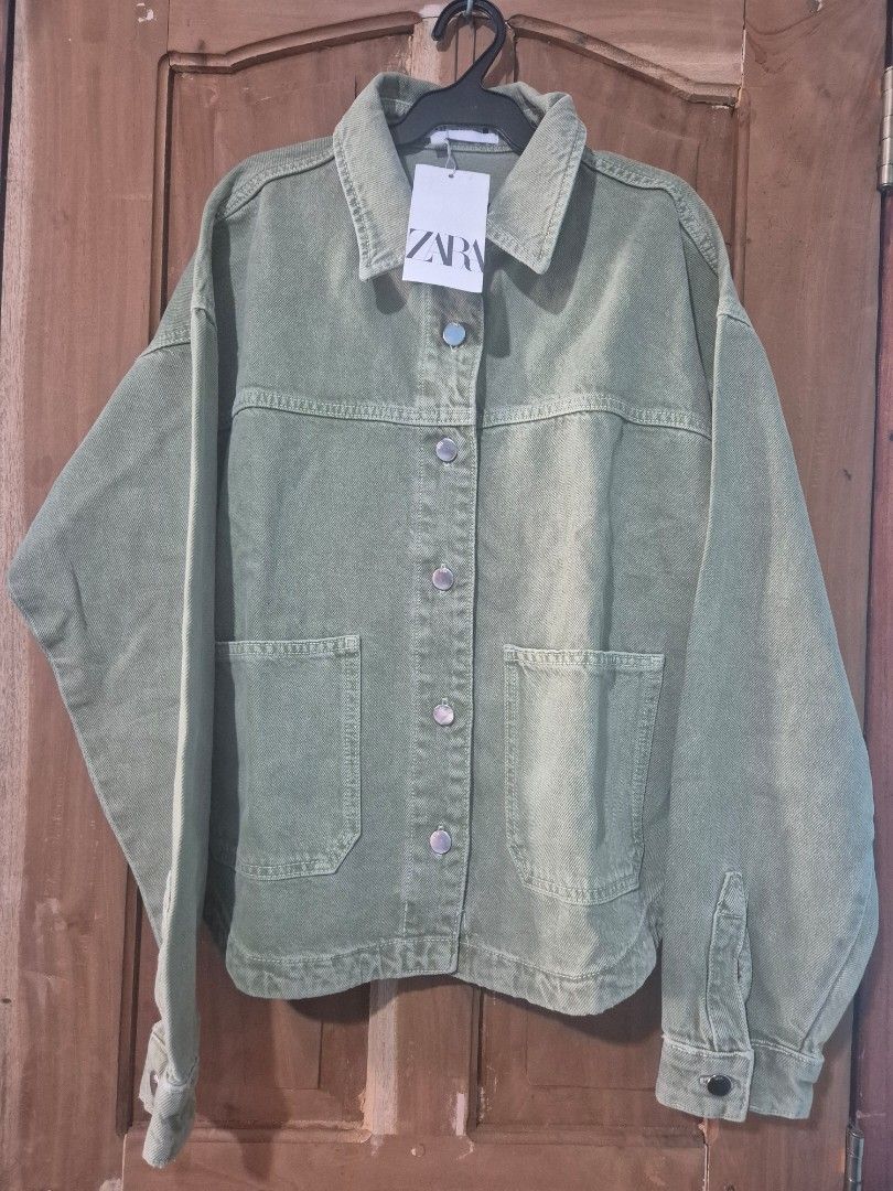 Zara Green Denim Jacket (Category: Coats, Jackets and Outerwear) located in Makati City. Submitted by neri_11 (Listing ID 1470419940, Image 1). Description: - Brand: Zara - Color: Trendy sage green - Condition: Brand new with original hang tag attached (includes a minor spot near the back yoke seam) - Details: Button-up front, metallic hardware, two chest pockets, long sleeves with button cuffs - Perfect layering piece for any casual outfit .