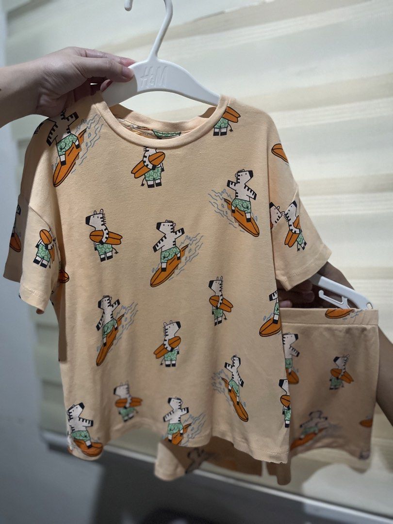 Zara Kids Zebra Surfer Pajama Set (Category: Babies & Kids Fashion) located in Quezon City. Submitted by brightrabbit_61b864 (Listing ID 1470376806, Image 1). Description: - Brand: Zara - Set includes: Short sleeve shirt and matching shorts - Design: Light peach with playful zebra surfing print - Material: Soft, breathable cotton - Condition: Brand new with H&M white hangers included - Perfect for: Sleepwear, pyjamas, or lounging at home.