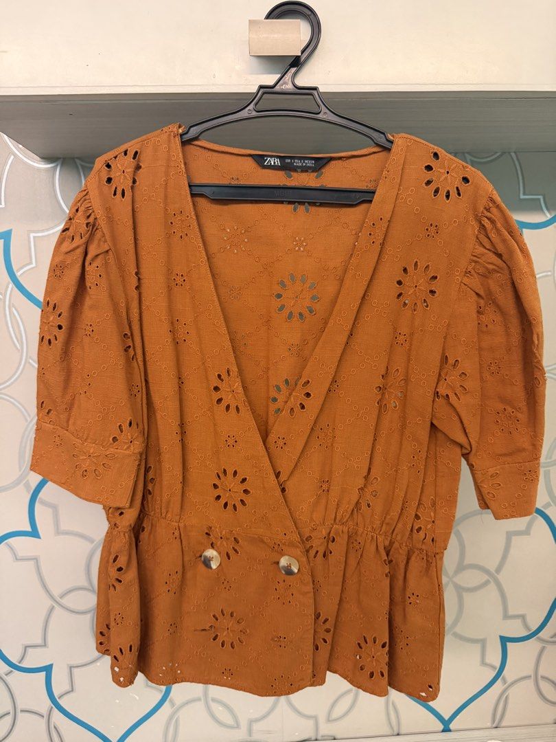 Zara Orange Eyelet Embroidered Wrap Blouse Size S (Category: Blouses) located in Calamba. Submitted by xnikkidg (Listing ID 1470451092, Image 1). Description: - Brand: Zara - Size: S (EUR/USA/MEX) - Color: Orange - Material: Textured weave with all-over eyelet embroidery - Design: Wrap style front with 2 buttons near the hem, short puff sleeves, and elasticated waist - Origin: Made in India.