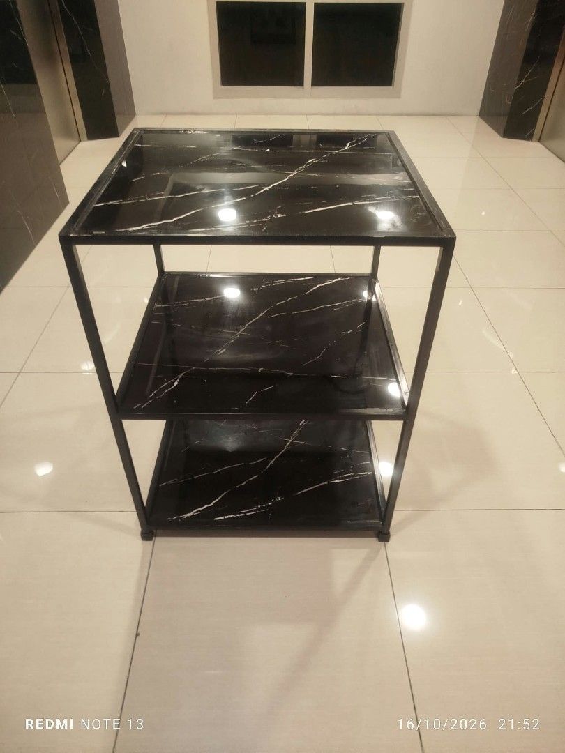 3-tier black marble pattern utility rack shelf table (Category: Shelves, Cabinets & Racks) located in Taguig. Submitted by manilyn_lau (Listing ID 1470667108, Image 1). Description: - Type: 3-tier storage shelf - Design: Black surface with white marble-style veining and dark metal frame - Build: Sturdy 4-leg structure - Versatile: Perfect for kitchen gear, books, or living room decor - Aesthetic: Clean, modern look that fits most interiors.