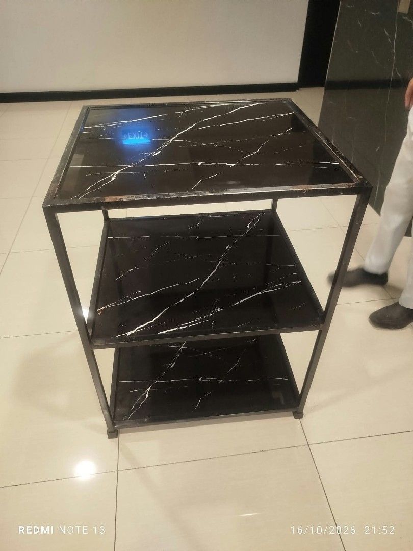 3-tier black marble pattern utility rack shelf table (Category: Shelves, Cabinets & Racks) located in Taguig. Submitted by manilyn_lau (Listing ID 1470667108, Image 3). Description: - Type: 3-tier storage shelf - Design: Black surface with white marble-style veining and dark metal frame - Build: Sturdy 4-leg structure - Versatile: Perfect for kitchen gear, books, or living room decor - Aesthetic: Clean, modern look that fits most interiors.
