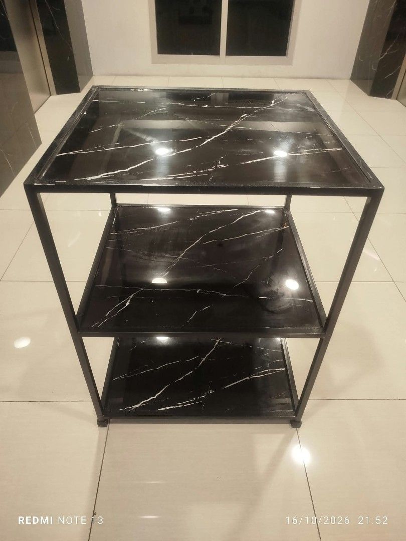 3-tier black marble pattern utility rack shelf table (Category: Shelves, Cabinets & Racks) located in Taguig. Submitted by manilyn_lau (Listing ID 1470667108, Image 2). Description: - Type: 3-tier storage shelf - Design: Black surface with white marble-style veining and dark metal frame - Build: Sturdy 4-leg structure - Versatile: Perfect for kitchen gear, books, or living room decor - Aesthetic: Clean, modern look that fits most interiors.