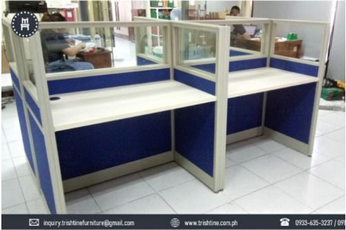 4-seater Workstation Fabric with Glass (Category: Office Furniture & Fixtures) located in Caloocan City. Submitted by jim.trishtineofficefurnitures (Listing ID 1470611226, Image 1). Description: - 2-desk modular office workstation setup - Cream-colored wooden desktop surfaces with sturdy metal framing - Blue fabric partitions with glass dividers on top for added privacy - Convenient cable management hole on the left desktop - Clean, professional 