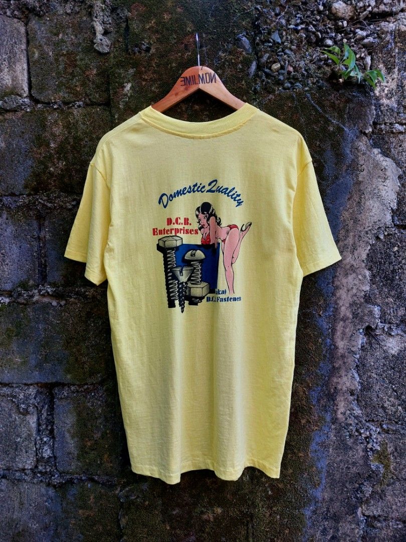 80's Promo Tee (Category: Tshirts & Polo Shirts ) located in Palayan City. Submitted by akhai420 (Listing ID 1470574640, Image 1). Description: - Brand/Style: Vintage 80's Hanes Beefy-T pocket tee - Design: D.C.B. Enterprises pinup graphics on front pocket and back - Material: Heavyweight 100% cotton, Made in U.S.A. - Era/Details: Classic single-stitch vintage tee - Size: L (42-44) - Condition: Good vintage feel, clean and vibrant color.