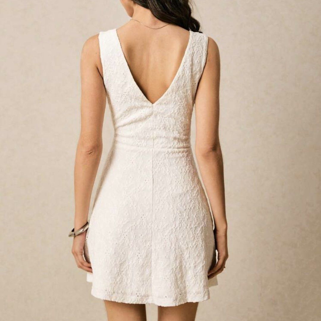 ✨ NEW ✨ White V-neck button-down eyelet mini dress (Category: Dresses) located in Manila. Submitted by cherrycherrycherrry (Listing ID 1470703494, Image 3). Description: White sleeveless mini dress with all-over eyelet lace pattern. Deep V-neckline on front and back. Functional button placket running down the center front. Fitted waist with a flared, A-line skirt hem. Fabric has a textured, floral embroidered look..