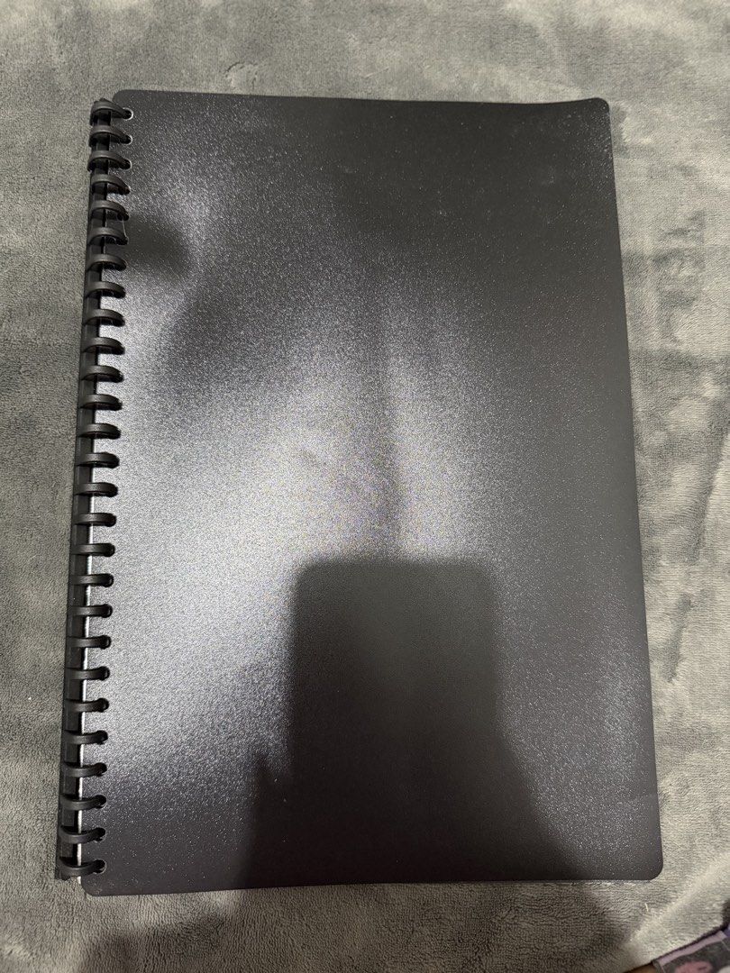 A4 Black Plastic Refillable Clearbook / Portfolio Folder (Category: Stationery & School Supplies) located in Mandaluyong City. Submitted by josa_xox0i8 (Listing ID 1470667300, Image 2). Description: Item: A4 Black Plastic Refillable Clearbook / Portfolio Folder Condition: Pre-owned, good working condition. Spine opens easily to add or remove sheet refills. Plastic sleeves show mild crinkling/wear. Features: Durable matte black PP cover with stand