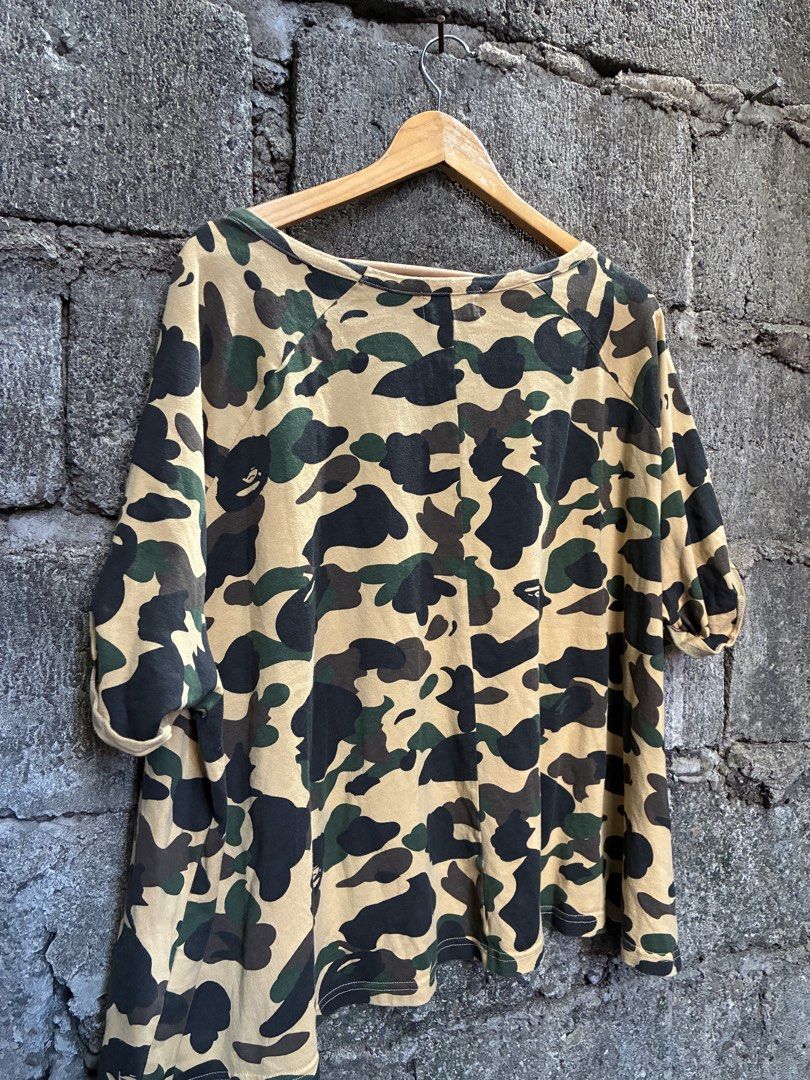 A Bathing Ape Bape Camo T-Shirt (Category: Tshirts & Polo Shirts ) located in Manila. Submitted by assortedgoodsv3 (Listing ID 1470620963, Image 2). Description: - Brand: A Bathing Ape (BAPE) - Design: Yellow camouflage all-over print (brown, green, and black tones) - Fit: Relaxed, casual streetwear - Details: Short sleeves, classic crew neck, iconic ape head logo tag near collar - Condition: Soft and worn-in fabric, ready for daily wear.