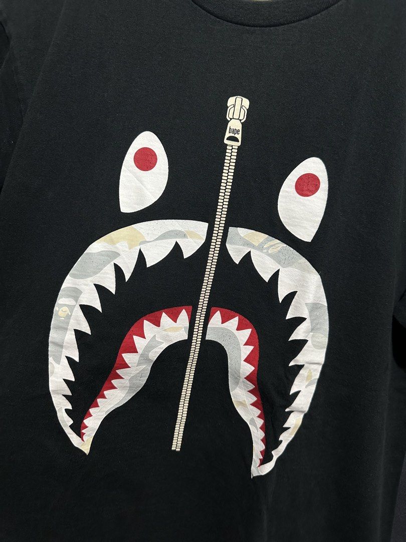 A Bathing Ape (BAPE) Shark Full-Zip Graphic Tee (Category: Tshirts & Polo Shirts ) located in Buenavista. Submitted by themodernrack (Listing ID 1470599126, Image 2). Description: Condition: Good Condition/Minimal Hairlines Measurements & Sizing: Size: Tagged Size XL (BAPE regular/classic fit; fits like Men’s L/XL) Width (Pit to Pit): 22” Length: 29”.