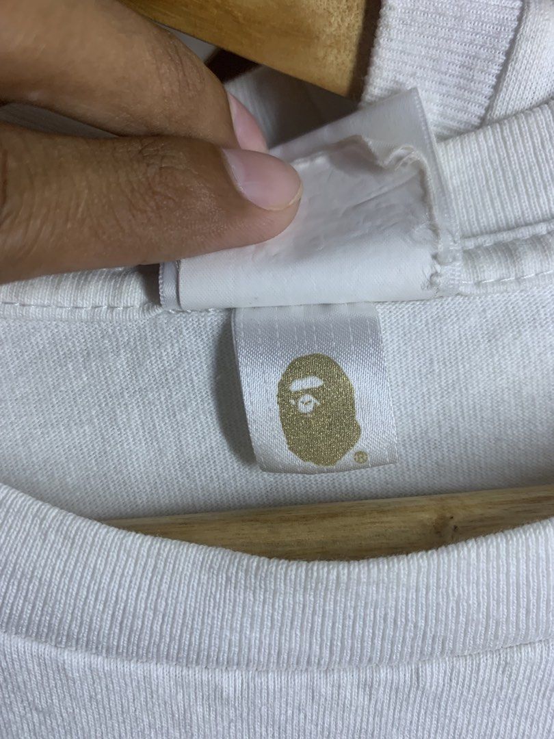 A Bathing Ape x Star Wars Bape Tee White Size M (Category: Tshirts & Polo Shirts ) located in Manila. Submitted by lstrthriftv1 (Listing ID 1470617506, Image 3). Description: - Brand: A Bathing Ape (BAPE) x Star Wars - Design: Baby Milo with BB-8 and droid graphic on front chest - Size: Medium (Yellow collar tag) - Material: 100% Cotton (Made in China) - Details: Classic crewneck, short sleeves, and signature sleeve ape tag near hem - Condition: 