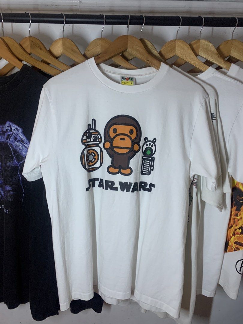 A Bathing Ape x Star Wars Bape Tee White Size M (Category: Tshirts & Polo Shirts ) located in Manila. Submitted by lstrthriftv1 (Listing ID 1470617506, Image 1). Description: - Brand: A Bathing Ape (BAPE) x Star Wars - Design: Baby Milo with BB-8 and droid graphic on front chest - Size: Medium (Yellow collar tag) - Material: 100% Cotton (Made in China) - Details: Classic crewneck, short sleeves, and signature sleeve ape tag near hem - Condition: 