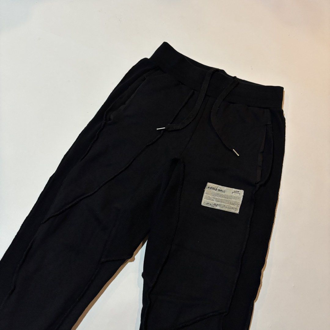 A-Cold-Wall Black Sweatpants (Category: Joggers) located in Dipolog. Submitted by dionato (Listing ID 1470673979, Image 3). Description: - Brand: A-Cold-Wall* - Color: Black - Material: Soft, premium cotton for an ultra-comfortable fit - Details: Signature industrial fabric patch on left leg, unique raw-edge side paneling - Hardware: Drawstring waistband with metallic aglets - Cuffs: Ribbed ankle cuffs - Style: Essential streetwear piece - Condit