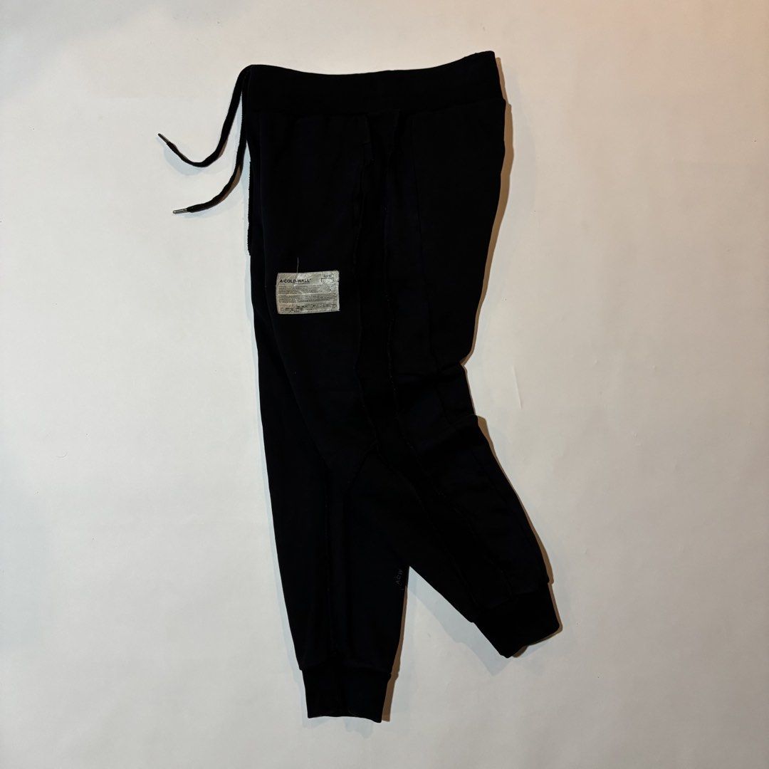 A-Cold-Wall Black Sweatpants (Category: Joggers) located in Dipolog. Submitted by dionato (Listing ID 1470673979, Image 1). Description: - Brand: A-Cold-Wall* - Color: Black - Material: Soft, premium cotton for an ultra-comfortable fit - Details: Signature industrial fabric patch on left leg, unique raw-edge side paneling - Hardware: Drawstring waistband with metallic aglets - Cuffs: Ribbed ankle cuffs - Style: Essential streetwear piece - Condit