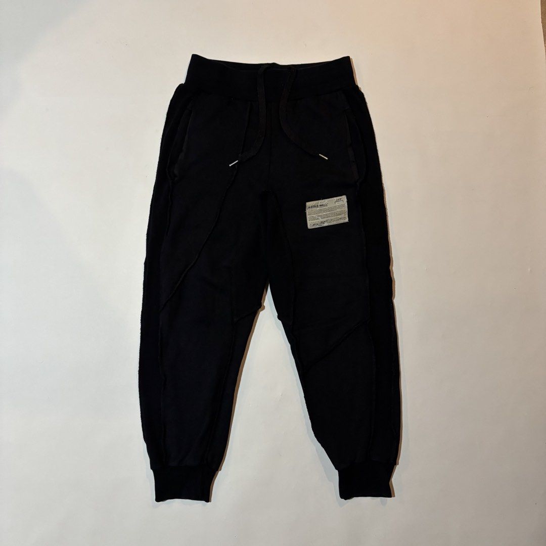 A-Cold-Wall Black Sweatpants (Category: Joggers) located in Dipolog. Submitted by dionato (Listing ID 1470673979, Image 2). Description: - Brand: A-Cold-Wall* - Color: Black - Material: Soft, premium cotton for an ultra-comfortable fit - Details: Signature industrial fabric patch on left leg, unique raw-edge side paneling - Hardware: Drawstring waistband with metallic aglets - Cuffs: Ribbed ankle cuffs - Style: Essential streetwear piece - Condit