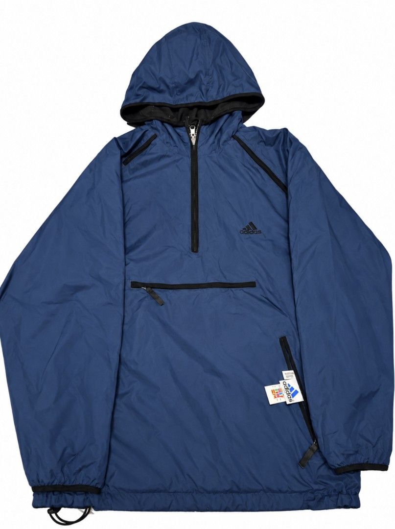 Adidas Blue Anorak Windbreaker Jacket (Category: Coats, Jackets and Outerwear) located in Bauang. Submitted by mr.acey (Listing ID 1470679752, Image 2). Description: - Authentic blue Adidas windbreaker with quarter zip and attached hood - Features a front kangaroo pocket and two secure side zippered pockets - Stylish dark blue contrast trim along seams and zipper paths - Classic embroidered Adidas logo on the upper chest - Lightweight shell mater