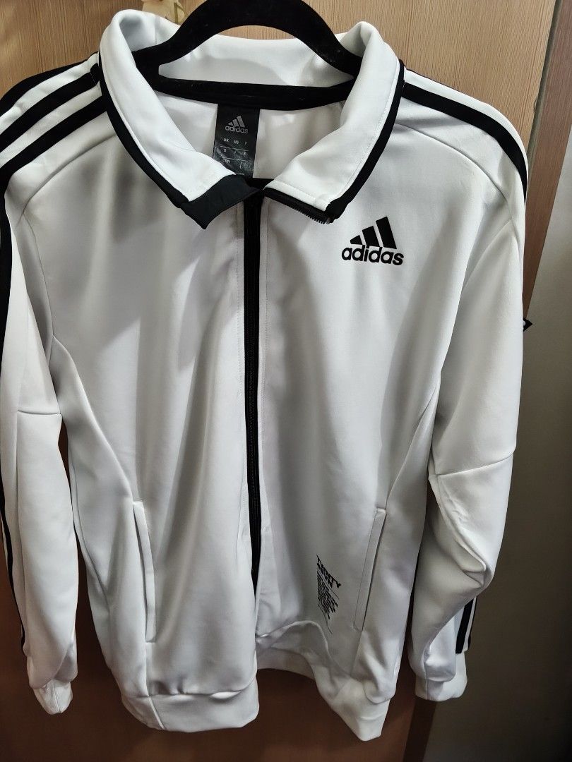 Adidas White Black 3-Stripes Track Jacket Size L (Category: Coats, Jackets and Outerwear) located in Quezon City. Submitted by queenbaby1819 (Listing ID 1470598057, Image 1). Description: - Brand: Adidas - Color: White with black 3-stripes and collar trim - Size: Large (tag at inner collar) - Features: Full zip closure, functional side pockets, graphic text near lower left hem - Origin: Made in Cambodia - Condition: Clean aesthetic, standard spor