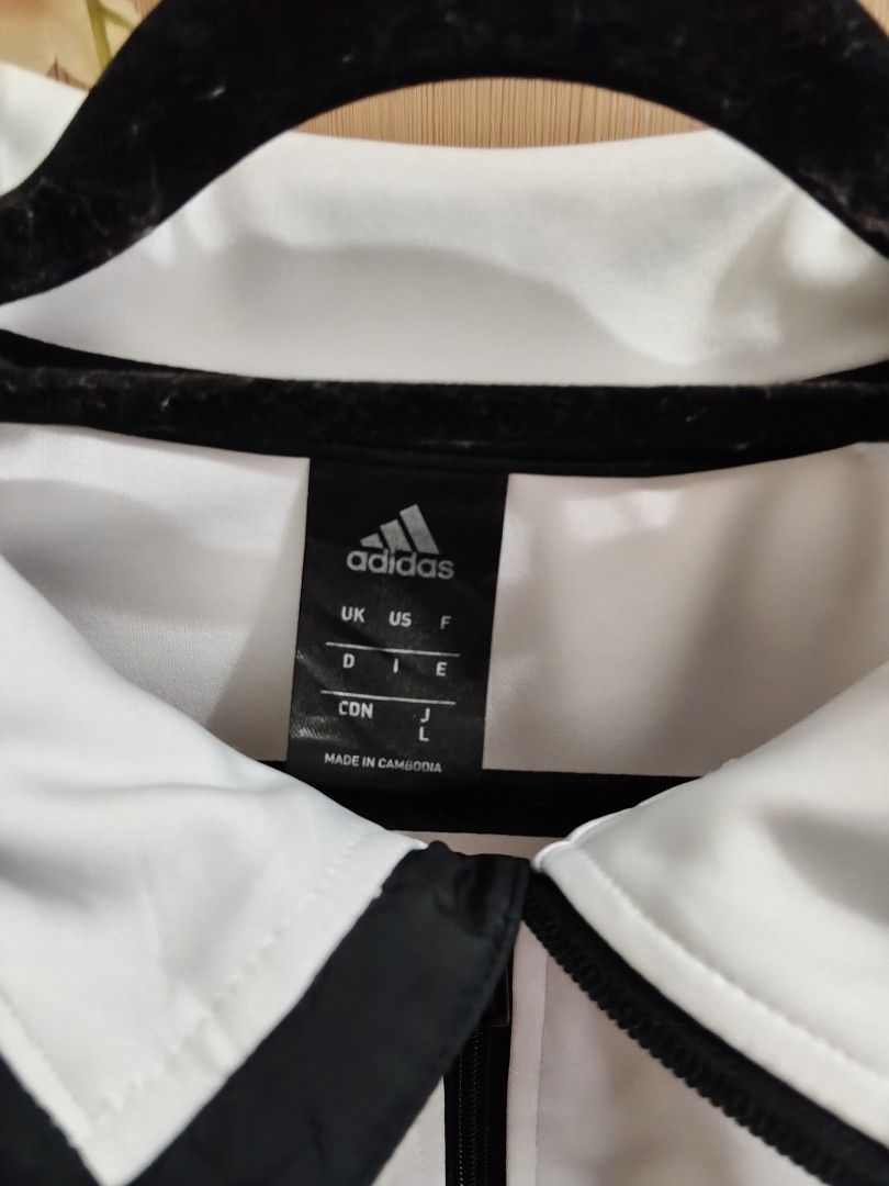 Adidas White Black 3-Stripes Track Jacket Size L (Category: Coats, Jackets and Outerwear) located in Quezon City. Submitted by queenbaby1819 (Listing ID 1470598057, Image 3). Description: - Brand: Adidas - Color: White with black 3-stripes and collar trim - Size: Large (tag at inner collar) - Features: Full zip closure, functional side pockets, graphic text near lower left hem - Origin: Made in Cambodia - Condition: Clean aesthetic, standard spor