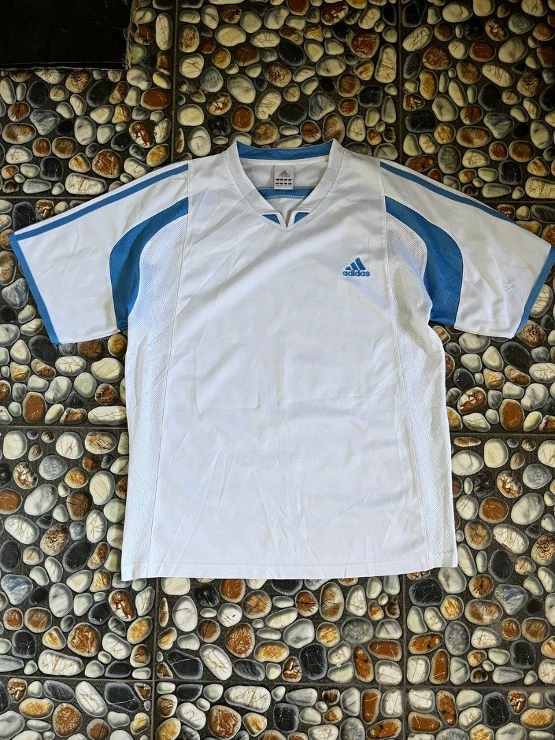 Adidas White Blue V-Neck Jersey (Category: Activewear) located in Baler. Submitted by vansonearth (Listing ID 1470701845, Image 1). Description: - Brand: Adidas - Color: White and blue with blue trim - Style: Classic retro sports jersey - Design: V-neck, short sleeves, and mesh panels on sides and shoulders - Branding: Embroidered blue Adidas logo on the chest - Size: XXL (multiple international sizing on tag) - Material: Breathable athletic fabr