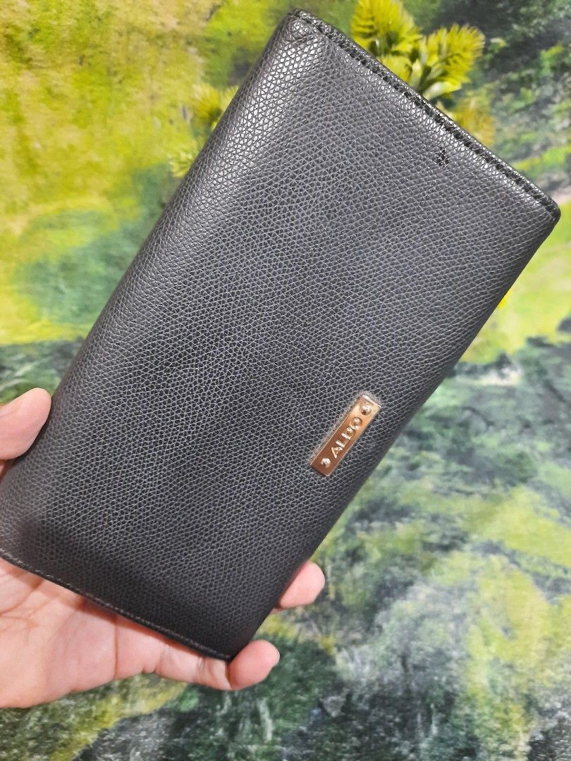 ALDO Black Long Wallet (Category: Wallets & Card holders) located in Baguio. Submitted by klayblakeb87803 (Listing ID 1470628393, Image 2). Description: - Color & Texture: Sleek black textured exterior with elegant gold hardware - Dimensions: Compact size measuring 7.5 by 4 inches - Closure: Secure magnetic snap closure - Storage: Multiple card slots and a convenient inner zippered pocket - Condition: Brand new with tag still tucked inside and a 