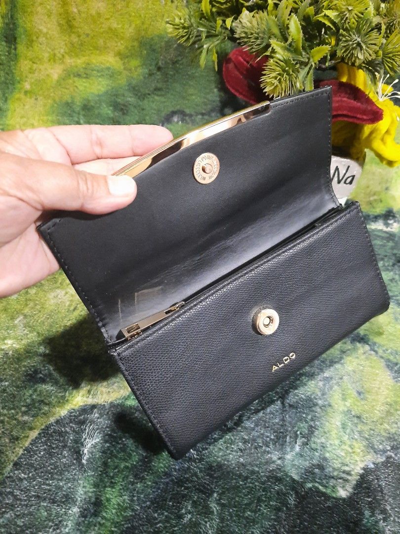 ALDO Black Long Wallet (Category: Wallets & Card holders) located in Baguio. Submitted by klayblakeb87803 (Listing ID 1470628393, Image 3). Description: - Color & Texture: Sleek black textured exterior with elegant gold hardware - Dimensions: Compact size measuring 7.5 by 4 inches - Closure: Secure magnetic snap closure - Storage: Multiple card slots and a convenient inner zippered pocket - Condition: Brand new with tag still tucked inside and a 