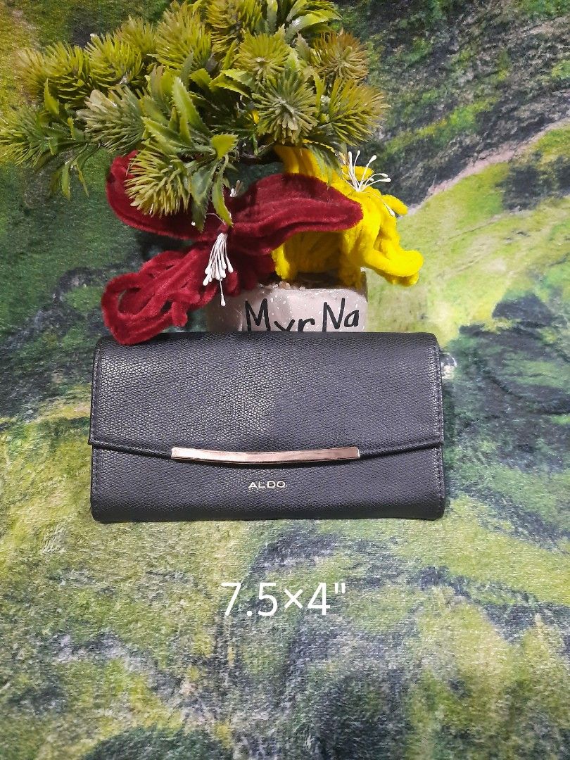ALDO Black Long Wallet (Category: Wallets & Card holders) located in Baguio. Submitted by klayblakeb87803 (Listing ID 1470628393, Image 1). Description: - Color & Texture: Sleek black textured exterior with elegant gold hardware - Dimensions: Compact size measuring 7.5 by 4 inches - Closure: Secure magnetic snap closure - Storage: Multiple card slots and a convenient inner zippered pocket - Condition: Brand new with tag still tucked inside and a 