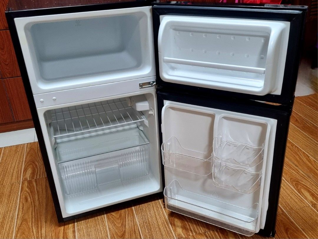 American Home 3.2 cu. ft. Two Door Mini Refrigerator (Category: Refrigerators and Freezers) located in Quezon City. Submitted by shelainefq (Listing ID 1470696942, Image 3). Description: - Brand: American Home Appliances - Color: Sleek black double door design - Layout: Top freezer compartment and bottom main fridge - Features: Includes wire shelf, crisper drawer, and convenient door shelves - Condition: Clean interior, well-maintained, and ready