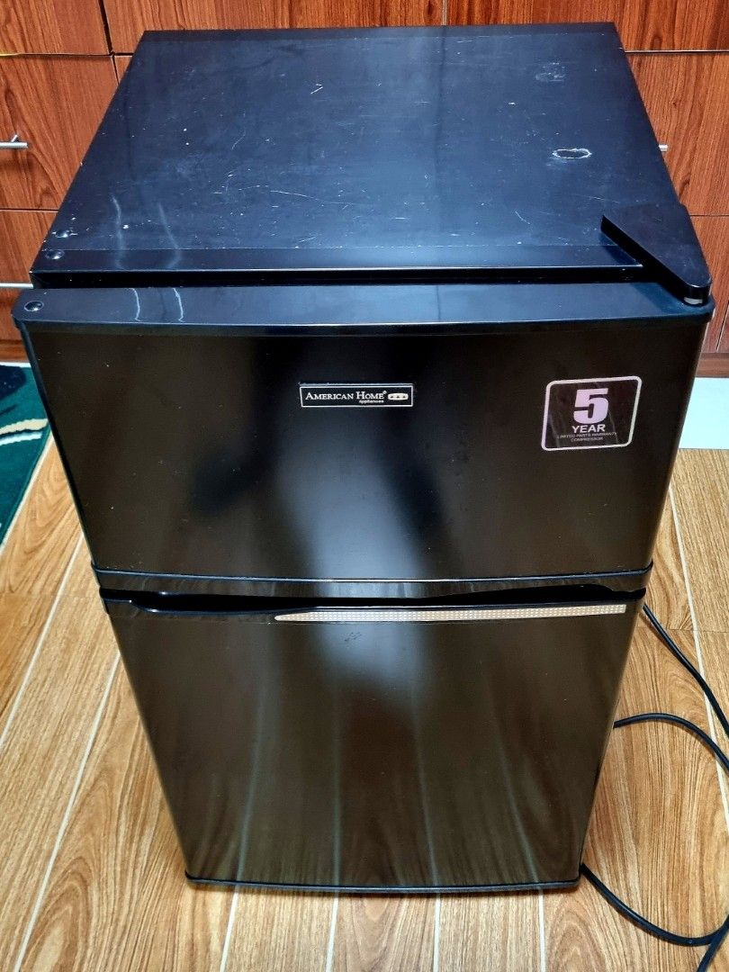 American Home 3.2 cu. ft. Two Door Mini Refrigerator (Category: Refrigerators and Freezers) located in Quezon City. Submitted by shelainefq (Listing ID 1470696942, Image 2). Description: - Brand: American Home Appliances - Color: Sleek black double door design - Layout: Top freezer compartment and bottom main fridge - Features: Includes wire shelf, crisper drawer, and convenient door shelves - Condition: Clean interior, well-maintained, and ready