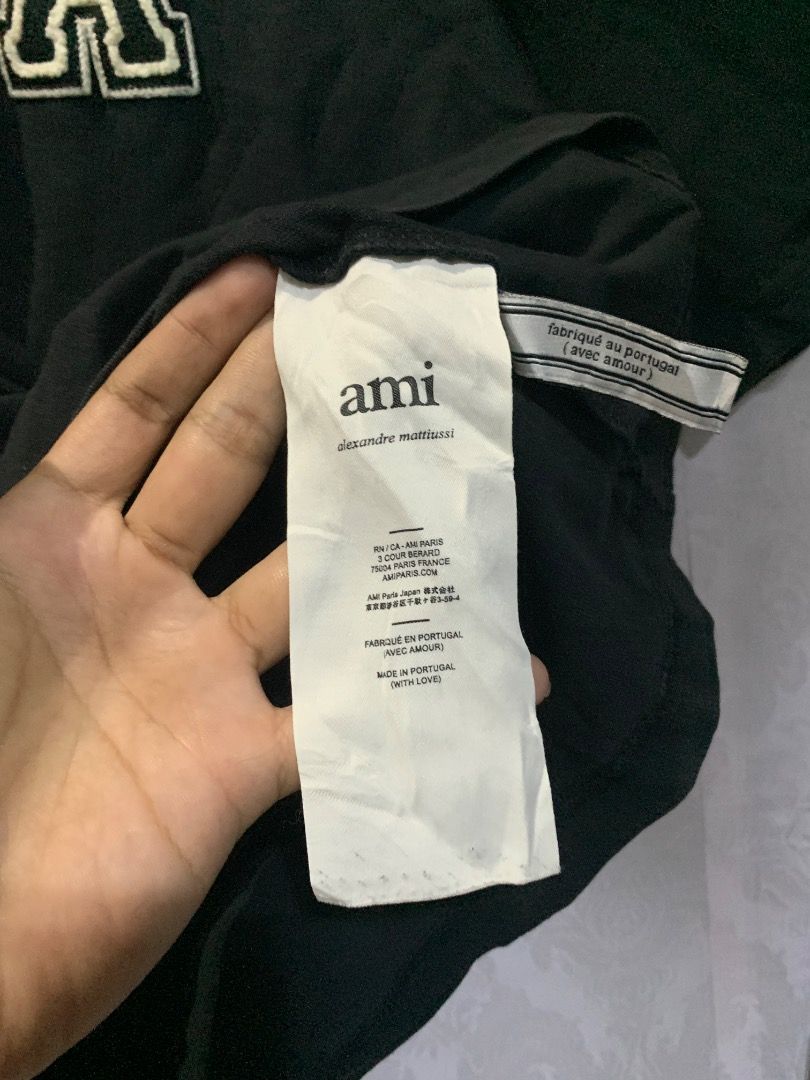 Ami Paris Heart Logo T-Shirt Black (Category: Shirts) located in Lucban. Submitted by mysticshark.0f6e1d (Listing ID 1470648421, Image 3). Description: Black t-shirt from Ami Paris. Large heart logo patch stitched on the chest. Made in Portugal from cotton fabric. Long washing tag attached inside showing brand details and care instructions..