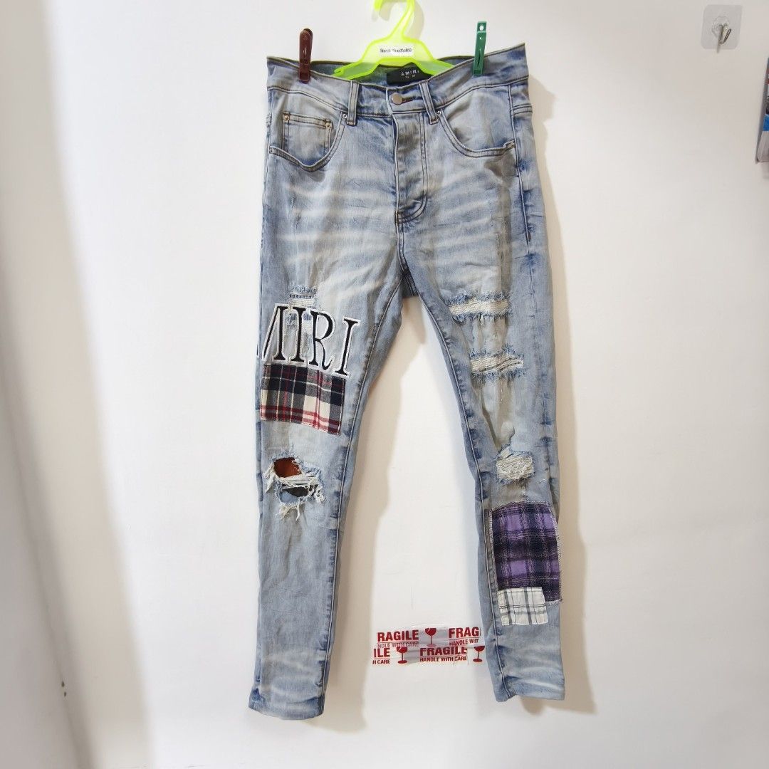 AMIRI Light Wash Distressed Patchwork Jeans Size 29 (Category: Jeans) located in Quezon City. Submitted by inrelationthrift (Listing ID 1470679416, Image 1). Description: - Brand: AMIRI - Style: Light wash distressed denim jeans with multi-color patchwork details - Size: 29-30(Waist measures approx. 15 inches flat) - Material: 98% cotton, 2% elastane - Features: Contrast brown back pocket, signature AMIRI embroidered lettering - Origin: Made in U