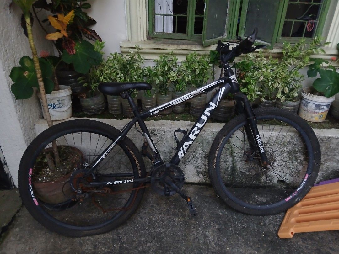 Arun Mountain Bike (Category: Bicycles) located in Manila. Submitted by bluecurryc30065 (Listing ID 1470656279, Image 1). Description: - Brand/Model: Arun Mountain Bike - Colorway: Black and White - Setup: Triple chainset with front suspension fork and black saddle - Condition: Heavy rust on chain, rear cassette, and fork components; frame has standard wear - Note: Requires maintenance or replacement parts before riding.