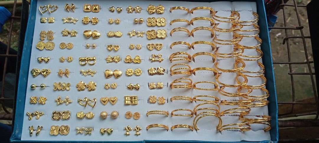 Assorted Gold Earrings and Hoops Collection (Category: Earrings) located in Talisay. Submitted by arnilynluc61194 (Listing ID 1470732527, Image 1). Description: - Large collection of gold-tone earrings and hoops - Variety of shapes including hearts, flowers, butterflies, and abstract motifs - Includes multiple sizes of classic hoop earrings - Comes with a convenient blue organizing box - Great for mixing and matching everyday outfits -bangkok gol