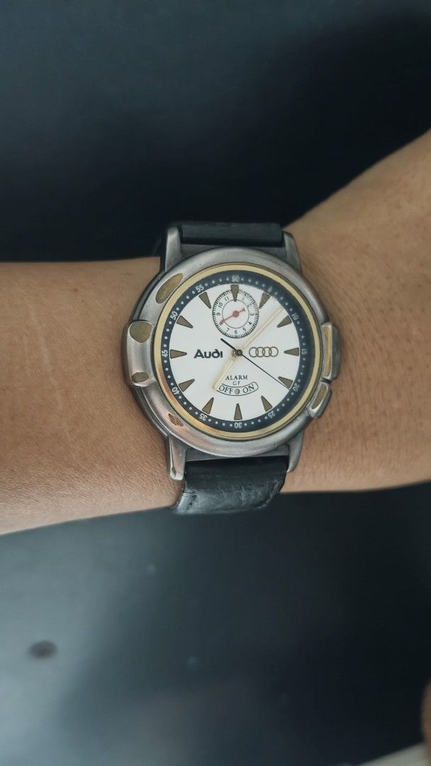 Audi Alarm Watch with Black Leather Strap (Category: Luxury Watches) located in Taguig. Submitted by mercyeugen28914 (Listing ID 1470683646, Image 2). Description: - Brand: Audi - Dial: White with gold bezel accents and sub-dial at 12 o'clock - Strap: Black leather - Special Feature: Alarm function with toggle at the bottom of the dial - Condition: Minor wear on the case and strap - Deal: Ready to ship or meet-up, message for details!.