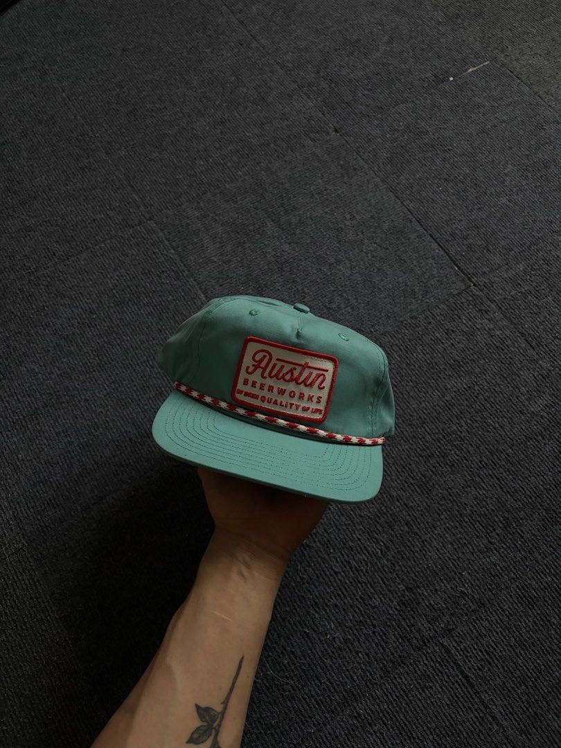 Austin Beerworks Green Snapback Hat (Category: Caps & Hats) located in Manila. Submitted by toys_hats005 (Listing ID 1470629154, Image 1). Description: - Brand: Austin Beerworks - Style: Green snapback cap with adjustable snap closure - Details: Woven front patch with red lettering, red and white twisted rope along the brim - Interior: Clean lining with white mesh structure inside front panels - Condition: Great overall condition.