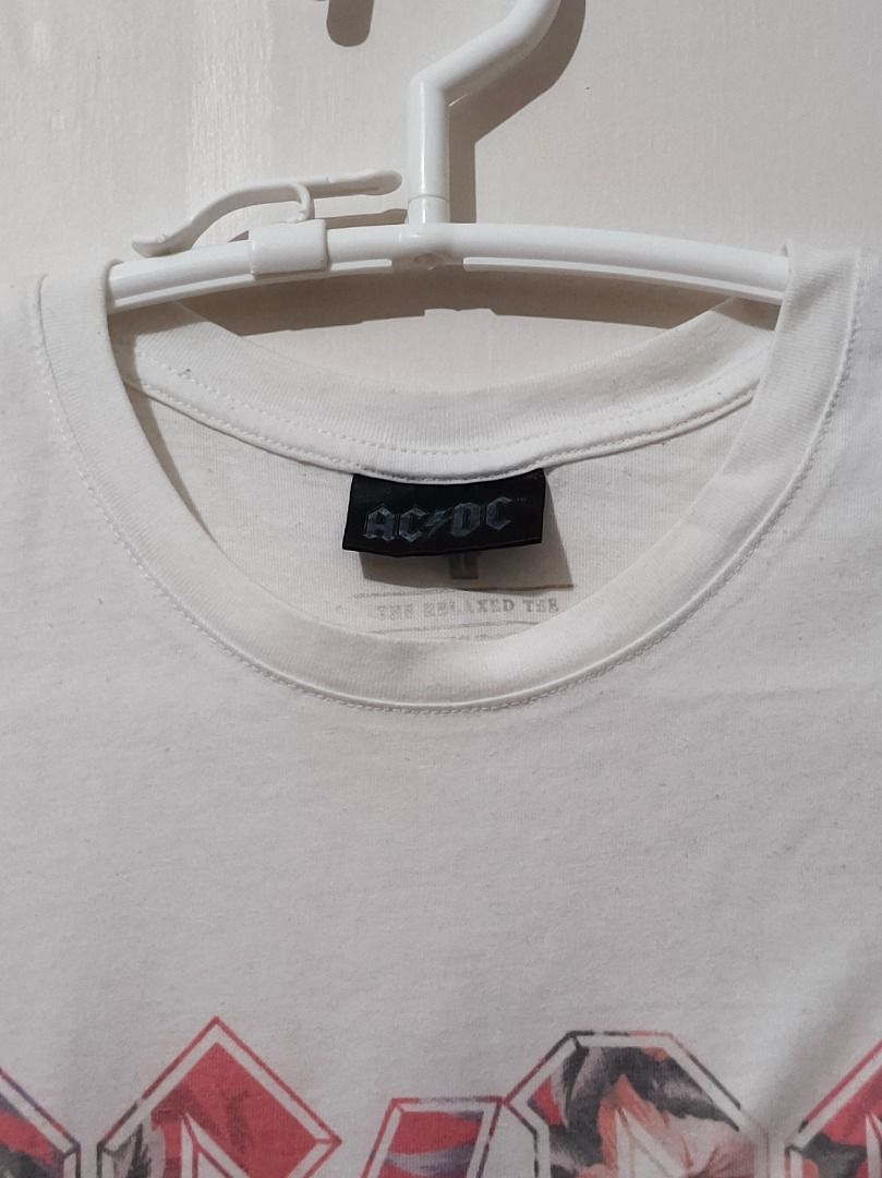 Authentic AC/DC Mono Leopard Print Logo White T-Shirt (Size L) (Category: Shirts) located in San Leonardo. Submitted by burgossanleonardo.12345 (Listing ID 1470679079, Image 2). Description: [AUTHENTIC BAND MERCH] Official licensed AC/DC short-sleeve graphic shirt. Features the iconic rock band logo on the front with a stylish monochromatic pink leopard print fill pattern inside the lettering. Cut from "The Relaxed Tee" collection line, offering 