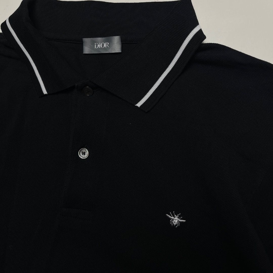 Authentic Dior Bee Embroidered Polo Shirt Black (Category: Tshirts & Polo Shirts ) located in Caloocan City. Submitted by achilles_grails (Listing ID 1470727876, Image 2). Description: - Brand: Dior - Item: Black knit polo shirt - Size: L - Material: 100% cotton (Made in Italy) - Details: Contrasting white stripes on collar and sleeves, iconic embroidered bee logo on chest, branded mother-of-pearl buttons - Condition: Clean and well-maintained - 