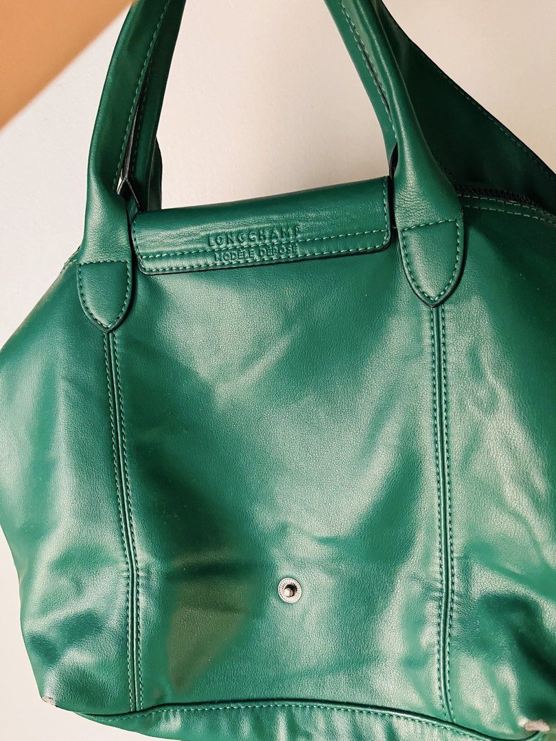 Authentic Longchamp Le Pliage Cuir (Category: Luxury Bags & Wallets) located in Pasig City. Submitted by fruitselling (Listing ID 1470638872, Image 2). Description: ☁️ Medium size, forest green LC w/ sling (embossed with brand) ☁️ Material 100% genuine grained cowhide leather (unlike the standard nylon Pliage bags) ☁️ Features a distinctive debossed jockey logo on the leather flap and a matching green snap button. ☁️ Hardware tonal green snap but
