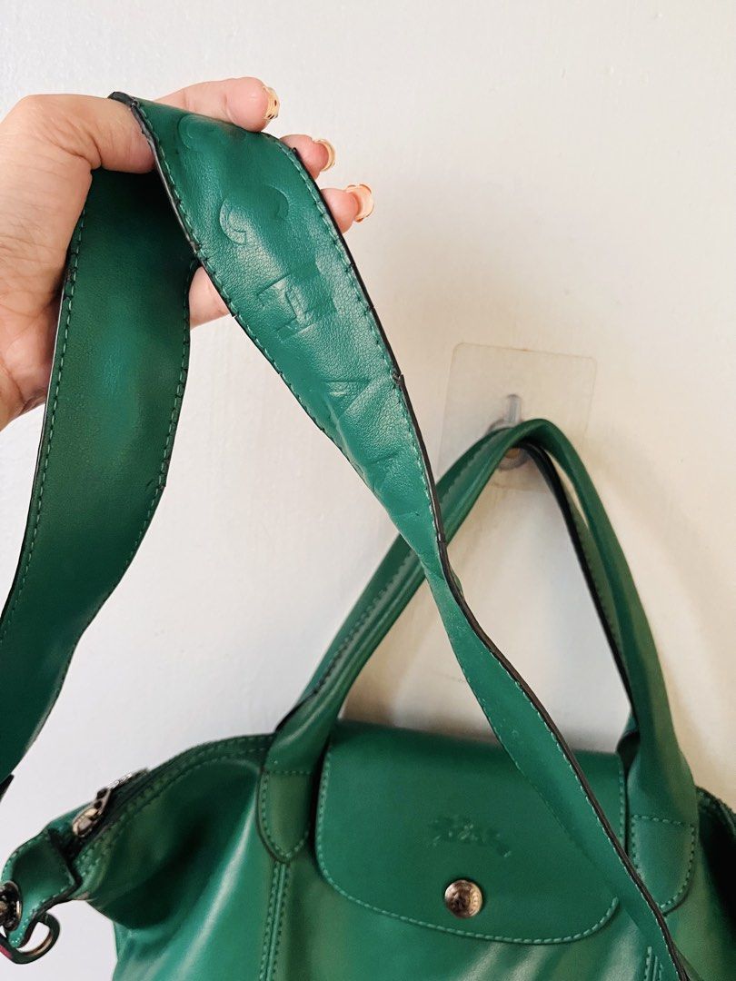 Authentic Longchamp Le Pliage Cuir (Category: Luxury Bags & Wallets) located in Pasig City. Submitted by fruitselling (Listing ID 1470638872, Image 3). Description: ☁️ Medium size, forest green LC w/ sling (embossed with brand) ☁️ Material 100% genuine grained cowhide leather (unlike the standard nylon Pliage bags) ☁️ Features a distinctive debossed jockey logo on the leather flap and a matching green snap button. ☁️ Hardware tonal green snap but
