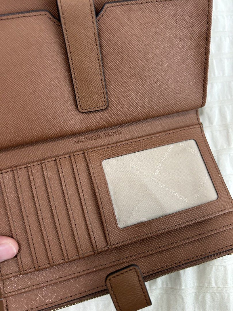 Authentic Michael Kors Jet Set Wallet ❤️ (Category: Wallets & Card holders) located in Taguig. Submitted by luckythriftph (Listing ID 1470586094, Image 3). Description: Selling my Michael Kors wallet in a beautiful, classic brown color with gold-tone hardware. ✨ Details: * Saffiano-textured leather * Elegant gold Michael Kors logo * Multiple card slots and ID window * Two zippered compartments * Spacious compartments for cash, receipts, and other
